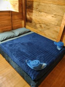 a bed with a blue blanket and a bowl on it at Cabaña Campestre - La Gloria in Guadalupe