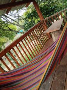 a hammock on a wooden deck with a bench at Cabaña Campestre - La Gloria in Guadalupe +2 photos