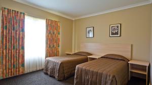 ein Hotelzimmer mit zwei Betten und einem Fenster in der Unterkunft Motel Le Grande in Albany