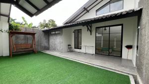 een patio met groen gras voor een huis bij Patria Villa Kayen in Kejayan