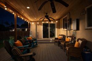 eine Veranda mit Stühlen, Deckenventilator und Beleuchtung in der Unterkunft Pool Oasis Central Villa in Grossmont