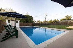 ein Swimmingpool mit zwei Stühlen und einem Sonnenschirm in der Unterkunft Pool Oasis Central Villa in Grossmont