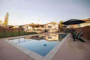 ein Swimmingpool mit zwei Stühlen und einem Sonnenschirm in der Unterkunft Pool Oasis Central Villa in Grossmont + 42 Fotos