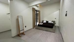 een slaapkamer met een bed en een spiegel in een kamer bij Patria Villa Kayen in Kejayan +14 foto's