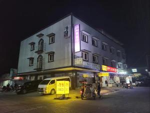a building with a sign on the side of it at night at Shine Hotel in Sampong