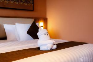 a stuffed snow man sitting on top of a bed at ME Villa Pererenan in Canggu