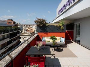 a balcony with a couch and tables on a building at Hotel Mercure Roma Corso Trieste in Rome