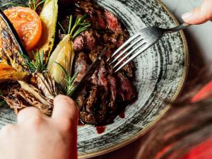 een persoon die een bord eten met een vork bij Hotel Mercure Roma Corso Trieste in Rome