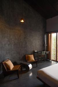 een slaapkamer met een bed, stoelen en een tafel bij De Hué in Hue