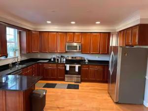 a kitchen with wooden cabinets and a stainless steel refrigerator at 25 Lux King Suite 1 - Private Bath, Nonsmoking in Arlington