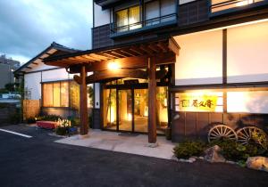 een gebouw met een verlichte gevel met ramen bij uedaonsen jukyuan in Ueda