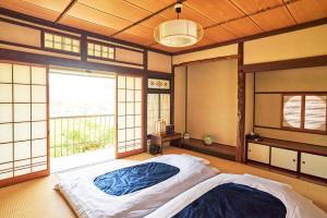 een slaapkamer met een bed en een groot raam bij uedaonsen jukyuan in Ueda