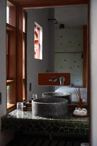 een badkamerbar met 2 wastafels en een spiegel bij De Hué in Hue +59 foto's