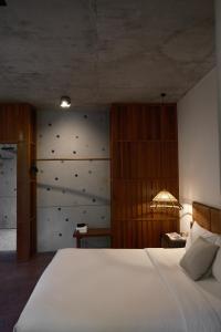 een slaapkamer met een groot wit bed en een muur bij De Hué in Hue