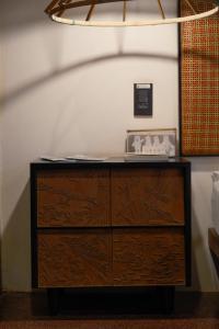een houten dressoir met een klok erop bij De Hué in Hue