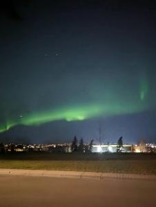 aurore dans le ciel au-dessus d'un champ la nuit dans l'établissement Calgary Star Cozy Home, à Calgary