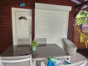 a table and chairs on a patio with a white door at Le Swing in Saint-François