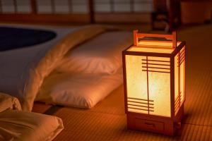 een lantaarn op de grond naast een bed bij uedaonsen jukyuan in Ueda +13 foto's