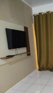 een flatscreen-tv aan een muur met een raam bij Ambiente Família e acolhedor in Porto Seguro