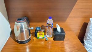 a table with a coffee maker and a bottle of water at Sang Surya Guest House in Bandung
