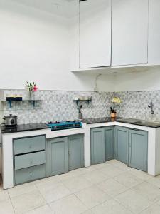 a kitchen with blue counters and white cabinets at Spacious House - Ngemplak, Surakarta in Kadipiro +16 photos