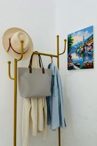 a towel rack with towels and a hat and a painting at Spacious House - Ngemplak, Surakarta in Kadipiro