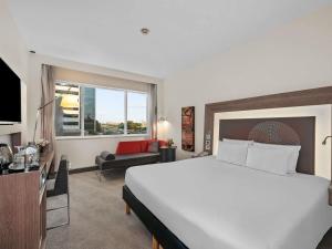 a bedroom with a large bed and a living room at Novotel Dubai World Trade Centre in Dubai