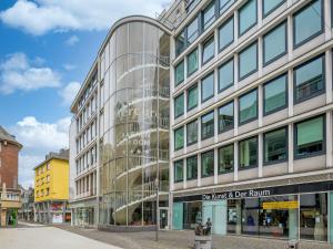 a large glass building on a city street at Mercure Hotel Aachen Am Dom in Aachen