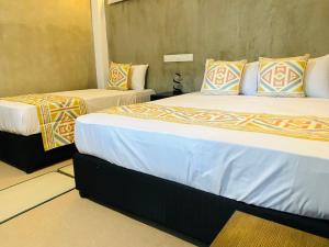 twee bedden in een hotelkamer met bij Coco Palm Villa and Cabanas in Tangalle +57 foto's