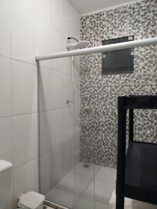 een badkamer met een glazen douche met toilet bij Ambiente Família e acolhedor in Porto Seguro