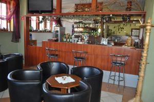 un bar con sillas de cuero negro y una mesa en Zajazd Magrani, en Lubawka