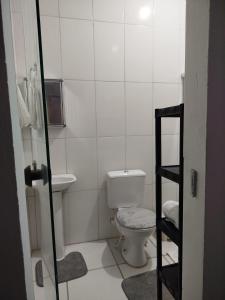 een witte badkamer met een toilet en een wastafel bij Ambiente Família e acolhedor in Porto Seguro +8 foto's