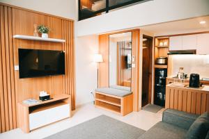 a living room with a television and a kitchen at Djayati Loft Stay in Yogyakarta