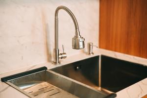 un évier de cuisine en acier inoxydable avec un robinet dans l'établissement Djayati Loft Stay, à Timuran 31 autres photos