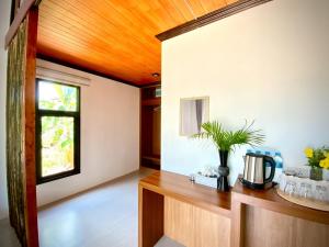 ein Wohnzimmer mit einer Holzdecke und einem Tisch in der Unterkunft AMORA Lanta in Ko Lanta Yai