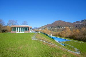 een huis met een zwembad in een grasveld bij Villa Intelvi in Castiglione dʼIntelvi