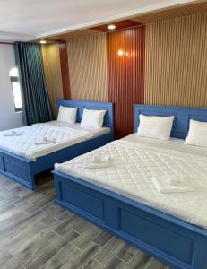 twee bedden naast elkaar in een kamer bij Hotel CÂY THỊ - Tây Ninh in Tây Ninh +7 foto's