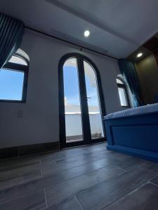 een kamer met grote ramen en een blauwe bank bij Hotel CÂY THỊ - Tây Ninh in Tây Ninh