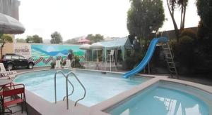 una piscina con scivolo di fronte a un edificio di Hotel Supreme a Baguio Altre 79 foto