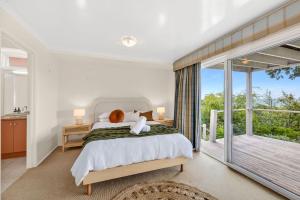 een slaapkamer met een groot bed en een balkon bij Louttit Bay Lookout in Lorne
