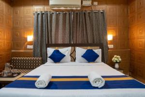 ein Schlafzimmer mit einem Bett mit blauen und weißen Kissen in der Unterkunft MAHIRA RESIDENCY in Port Blair + 76 Fotos
