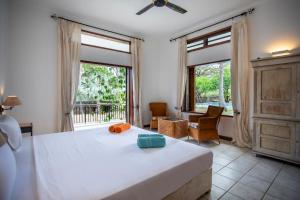 una camera da letto con un letto e una grande finestra di The Villa - Le Morne - Kite, Golf & Beach a Le Morne Altre 161 foto