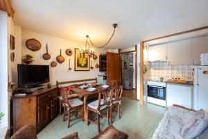 een keuken en eetkamer met een tafel en een televisie bij Residence Dolonne - Happy Rentals in Courmayeur