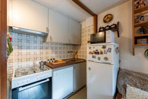 een keuken met witte apparatuur en een witte koelkast bij Residence Dolonne - Happy Rentals in Courmayeur