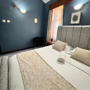 a bedroom with two beds and a blue wall at 3Bedroom Villa-Shanzu, Mombasa in Mombasa