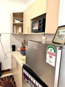 a kitchen with a refrigerator with a microwave at 3Bedroom Villa-Shanzu, Mombasa in Mombasa