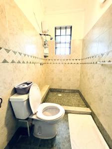 a bathroom with a toilet and a window at 3Bedroom Villa-Shanzu, Mombasa in Mombasa +6 photos