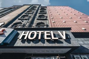 een hotelbord aan de zijkant van een gebouw bij V Hotel in Gumi