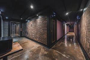 una stanza vuota con un muro di mattoni di V Hotel a Gumi