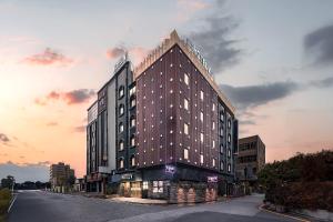 ein hohes Gebäude an der Straßenseite in der Unterkunft V Hotel in Gumi